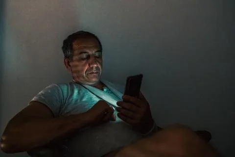 Using mobile apps technology on cell phone late at night Stock Photos