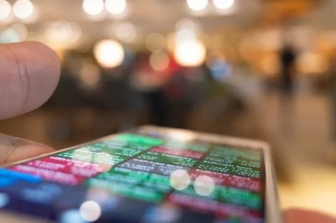 Using a mobile device to check market data Stock Photos