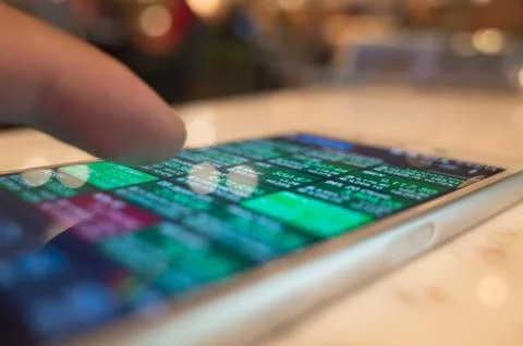 Using a mobile device to check market data Stock Photos
