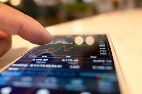 Using a mobile device to check market data Stock Photos