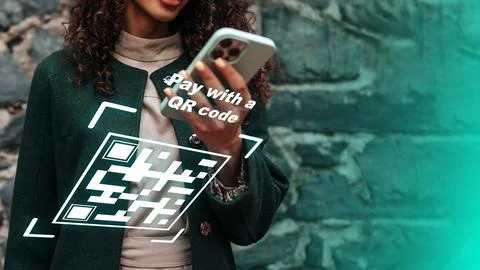 Using a mobile device to make an online payment with a QR code in an urban Stock Photos