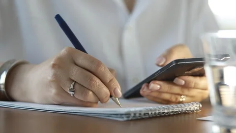  Using a mobile phone. A girl writes information from a smartphone in a notebook Stock Footage 110722474