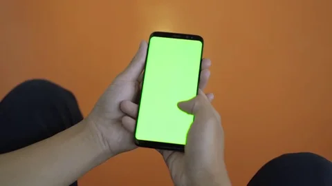 Using mobile phone with green screen in public. Thumb swiping through display Stock Footage 80555643