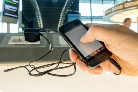 Using a mobile phone while charging the battery at the airport Stock Photos
