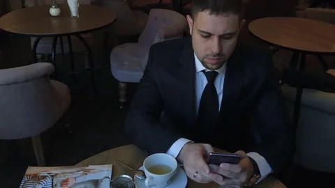 Using mobile phone while sitting in restaraunt Stock Footage