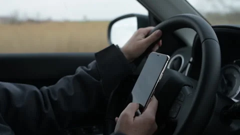 Using mobile smart phone while driving the car down the highway road Stock Footage 150428117