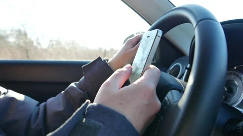 Using mobile smart phone while driving the car down the highway road Stock Footage 168430874