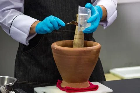 Using a mortar and pestle to pound ingredients for thai food, Pound mortar Stock Photos