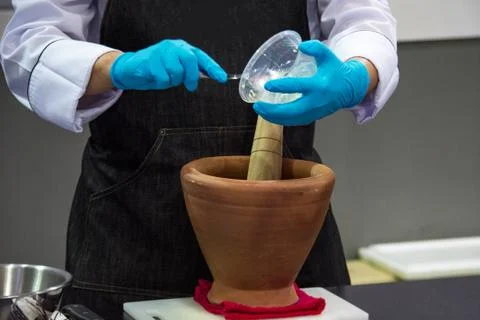 Using a mortar and pestle to pound ingredients for thai food, Pound mortar Stock Photos