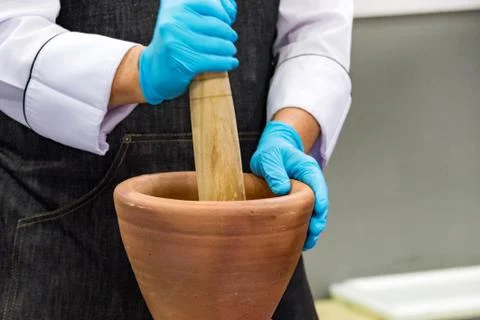 Using a mortar and pestle to pound ingredients for thai food, Pound mortar Stock Photos
