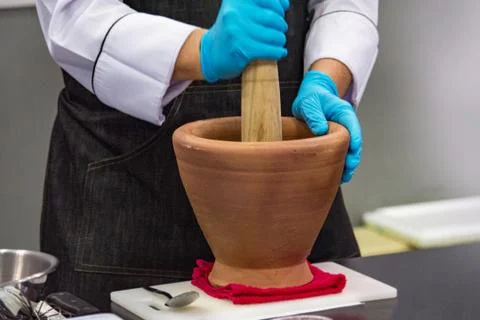 Using a mortar and pestle to pound ingredients for thai food, Pound mortar Stock Photos