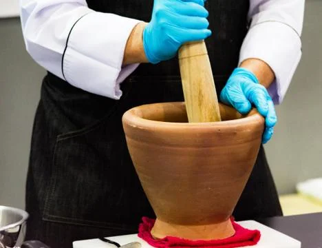 Using a mortar and pestle to pound ingredients for thai food, Pound mortar Stock Photos