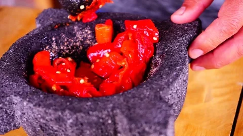 Using a morter with red hot chilli peppers Stock Footage 129402090