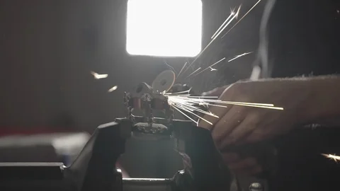 Using a multi tool in workshop with sparks Stock Footage 125446024