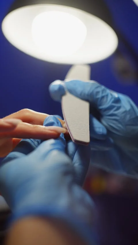 Using a nail file, the master shapes a new, beautiful nail plate. Stock-Footage 343537638
