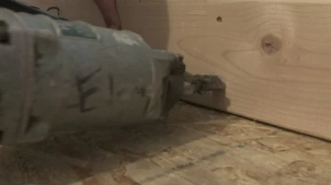 Using a nail gun on a section of framing at a construction site Stock Footage 47377359