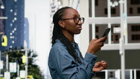 Using navigation app on smartphone, black woman walking around the city Stock Footage 334171485
