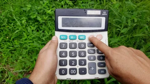 Using an Old Calculator Outdoors on Grass While Pressing the Clear Button Stock Footage 295667804