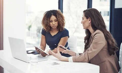 Using online resources for a team task. two businesswomen using a digital tablet Foto stock