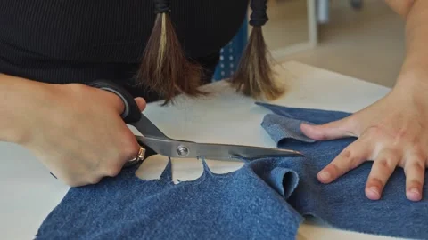 Using a pair of scissors, the tailor shapes a denim piece into a palm-like form. Vídeos de archivo 314134049