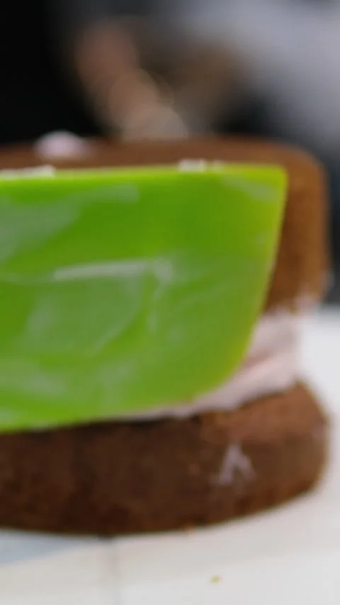 Using a palette knife, decorate a bento cake with a flower made of cream Video stock 279724859