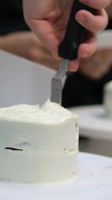 Using a palette knife, decorate a bento cake with a flower made of cream Stock Footage 279724902