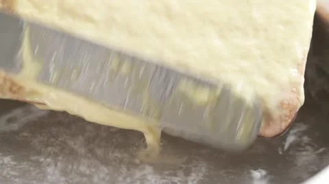 Using a palette knife to scrape thin strips of spatzle dough into boiling water Stock Footage 24662263