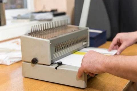 Using a paper binding machine Stock Photos