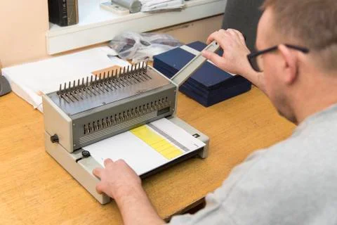 Using a paper binding machine Stock Photos