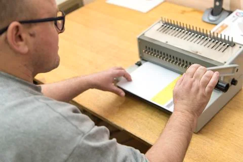 Using a paper binding machine Stock Photos