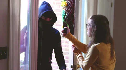Using pepper spray on criminal at door Stock Footage