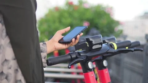 Using a phone to scan the QR code on an electric scooter for the ride Stock Footage 340941089