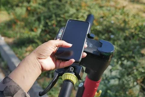 Using a phone to scan the QR code of the electric scooter Stock-Fotos