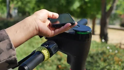 Using a phone to unlock a scooter at a park Stock-Footage 341907946