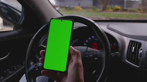 Using the phone while driving in the car. Phone with a green screen Stock Footage 165299809