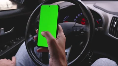 Using the phone while driving in the car. Phone with a green screen Stock Footage 165300239