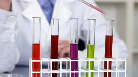 Using pipette to add red substance to test tubes with chemicals HD Stock Footage 10649039