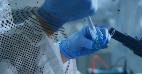 Using pipette, researcher in PPE transferring into vial at bench, microscope arm Stock Photos