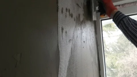 Using of plastic grid for plaster of walls Stock Footage 104416210