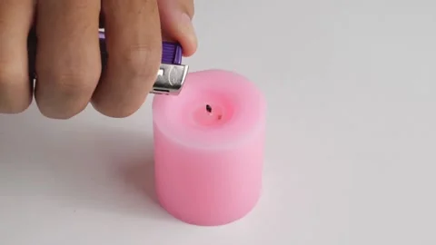 Using a point lighter one candle wick, pink used in some festivals The fire g Stock Footage 188427271