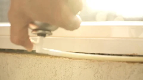 Using polyurethane foam to fill gaps during installing a window. Stockbeeldmateriaal 124679056