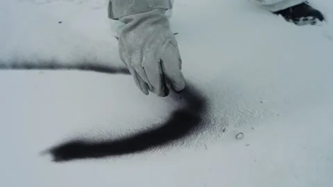 Using powder to identify affected snow areas. Technician applies dark powder to Video stock 342744830