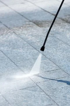 Using a pressure hose to power clean paving Stock Photos