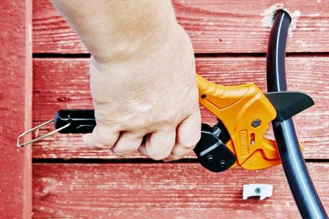 Using ratchet shears to cut HDPE pipes when installing an external drinking Foto stock