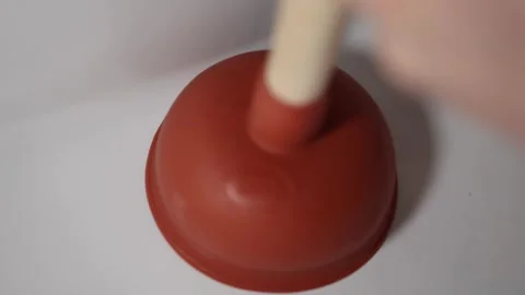 Using red plunger to unclog dirty sink drain strong motion and splash captured i Stock Footage 309334327