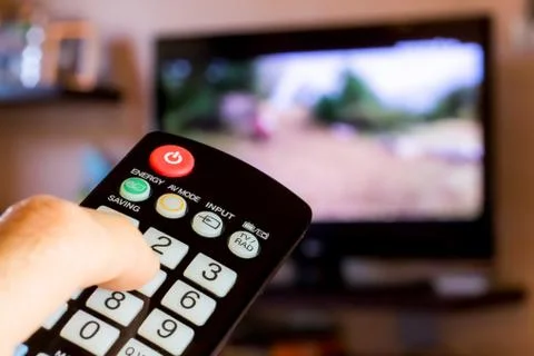 Using the remote control to change channesl on Tv Stock Photos
