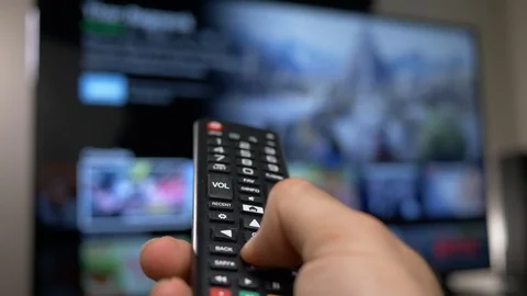 Using a Remote Control With a Smart TV Television To Select a Movie Stock Footage 92643315