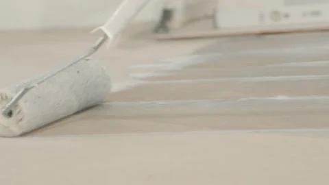 Using a roller to spread adhesive on the floor before laying tiles. Home Stock Footage 340916097