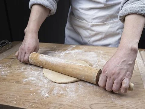 Using a rolling pin on dough. Stock Photos