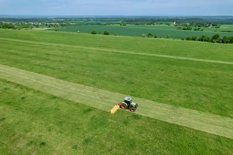 Using a rotary mower, tractor efficiently trims grass. Top view of mowing grass Stock Photos